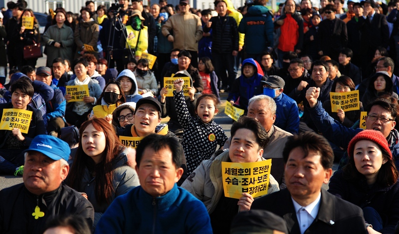 416가족협의회, 4.16연대,  세월호잊지않는 목포지역공동실천회의, 박근혜퇴진 광주시민운동본부, 세월호 3년상을 치르는 광주시민상주모임, 박근혜정권퇴진 전남운동본부 세월호 특위는 1일 오후 인양된 세월호가 들어와 있는 목포신외항에서 ‘미수습자 온전한 수습과 세월호참사 진상규명 촉구대회’를 열고 있다. 한 아이가 힘차게 손을 치켜올리며 구호를 외치고 있다.