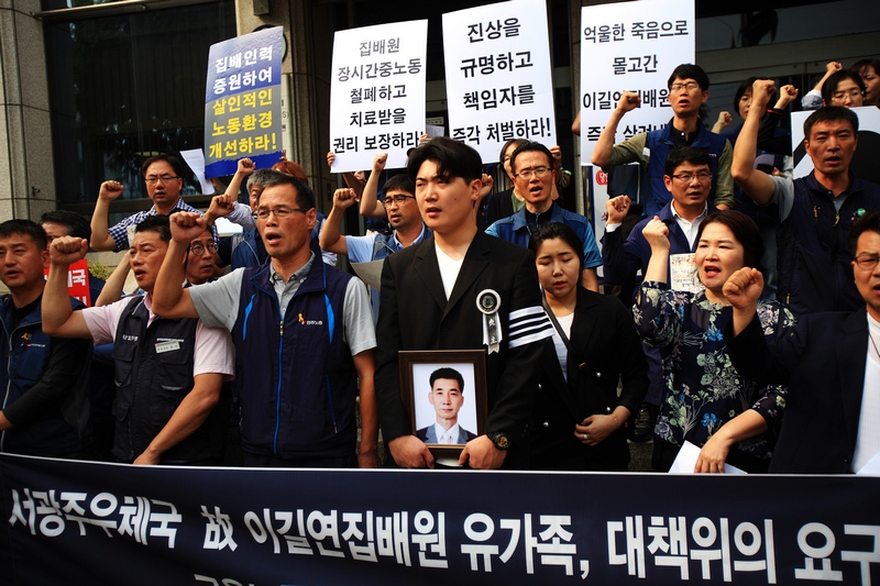 고 이길연 집배원 아들 동하씨가 고인 영정을 들고 이날 기자회견에 참여해 우정사업본부와 서광주우체국을 규탄하고 있다.
