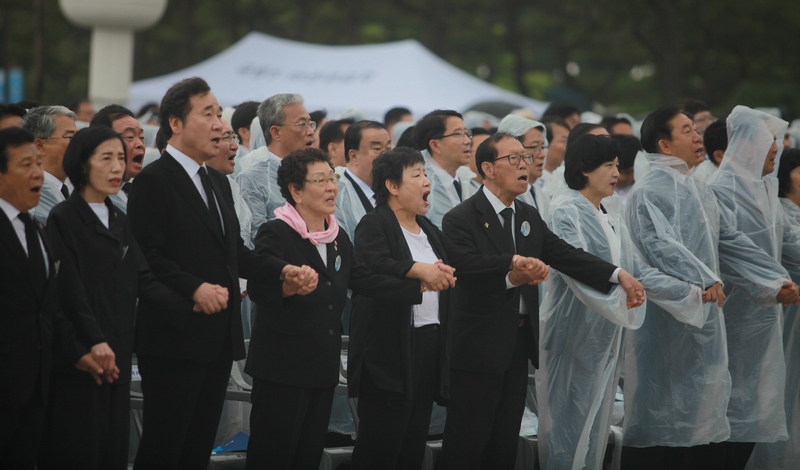 이낙연 총리와 5·18 유족들이 제38주년 5·18 기념식 마지막 순서로 모두 일어서서 손을 맞잡고 앞뒤로 흔들면서 ‘임을 위한 행진곡’을 합창하고 있다.