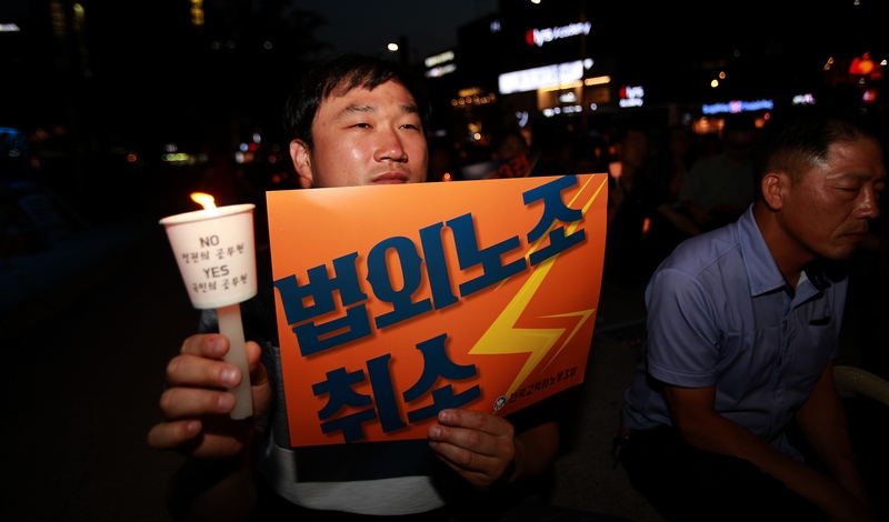 전교조 광주지부는 12일 오후 광주 5·18민주광장에서 조합원 등 1백5십여 명이 참여한 가운데 촛불을 들고 “법외노조 철회하라” 등을 외쳤다. 이날 결의대회에 참가한 한 선생님이 촛불과 ‘법외노조 철회’ 손피켓을 들고 있다.