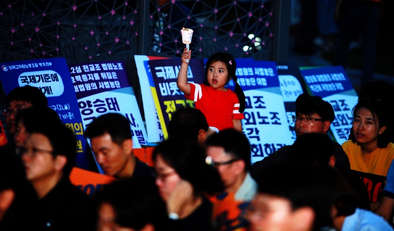 전교조 광주지부는 12일 오후 광주 5·18민주광장에서 조합원 등 1백5십여 명이 참여한 가운데 촛불을 들고 “법외노조 철회하라” 등을 외쳤다. 이날 결의대회에 부모와 함께 참여한 한 아이가 촛불을 치켜들고 있다.