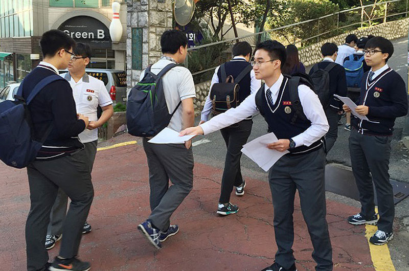 2015년 10월 5일 오전 서울 충암 중고등학교 정문에서 이 학교 법-사회 동아리 소속 학생들이 학교 급식 비리를 다룬 전단지를 배포하고 있다.