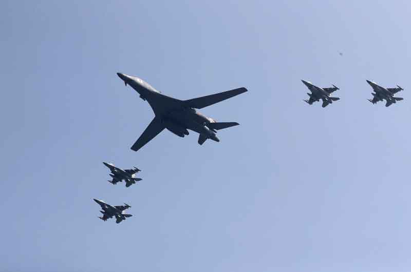 13일 한국 평택 오산 기지 상공을 비행하는 미 공군 B-1B 폭격기(가운데)와 호위비행에 나선 한국 공군의 F-15K