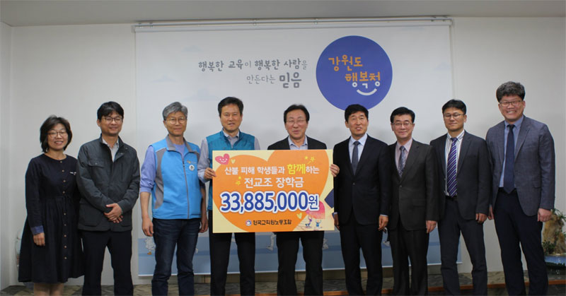 권정오 전교조 위원장(왼쪽에서 네번째)이 민병희 강원도교육감(왼쪽에서 다섯번째)에게 강원도 산불 피해 학생 지원 장학금을 전달하고 있다.