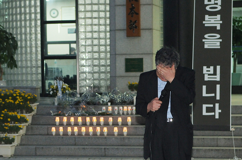 총장직선제 사수를 요구하며 부산대 본관 건물에서 투신 사망한 故 고현철(54) 국문과 교수의 장례가 21일 엄수된다. 19일 본관 앞에서 열린 추모대회에서 고 교수의 동료 교수가 고인을 추모하며 눈물을 훔치고 있다.