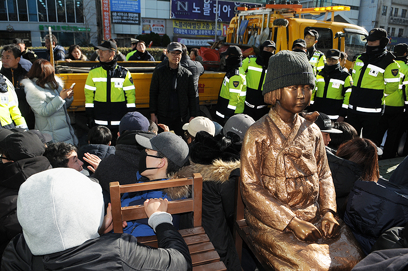 한일 ‘위안부’ 합의 1년을 맞은 28일 부산 일본영사관 앞에 처음으로 평화의 소녀상이 기습 설치됐다. 그러나 경찰과 동구청은 4시간 30분 만에 이를 강제 철거했다. 소녀상을 지키고 있는 시민과 대학생.