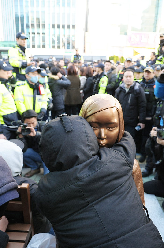 한일 ‘위안부’ 합의 1년을 맞은 28일 부산 일본영사관 앞에 처음으로 평화의 소녀상이 기습 설치됐다. 그러나 경찰과 동구청은 4시간 30분 만에 이를 강제 철거했다. 소녀상을 끌어안고 끝까지 지키고 있는 한 시민의 모습.