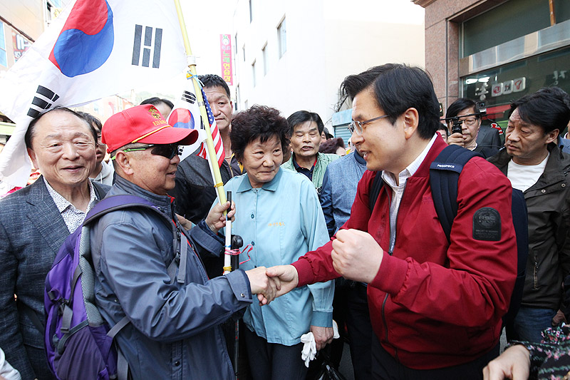 황교안 자유한국당 대표가 7일 부산 덕포시장 인근에서 ‘국민 속으로’를 외치며 민생투쟁 대장정에 나서고 있다. 태극기와 성조기를 든 지지자와 인사를 나누는 황 대표.