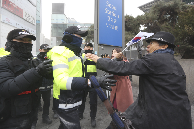 현송월 삼지연 관현악단 단장이 이끄는 북한 예술단 사전 점검단이 서울역에 도착한 지난해 1월22일 오전 서울역에서 보수단체가 북한의 평창동계올림픽 반대 기자회견을 열어 인공기와 김정은 사진을 불태우는 퍼포먼스 도중 경찰과 마찰을 빚고 있다.