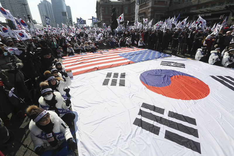 1일 오후 서울 중구 서울역광장에서 열린 ‘박근혜 전 대통령 석방 태극기 집회’에서 참가자들이 태극기와 성조기를 흔들고 있다.