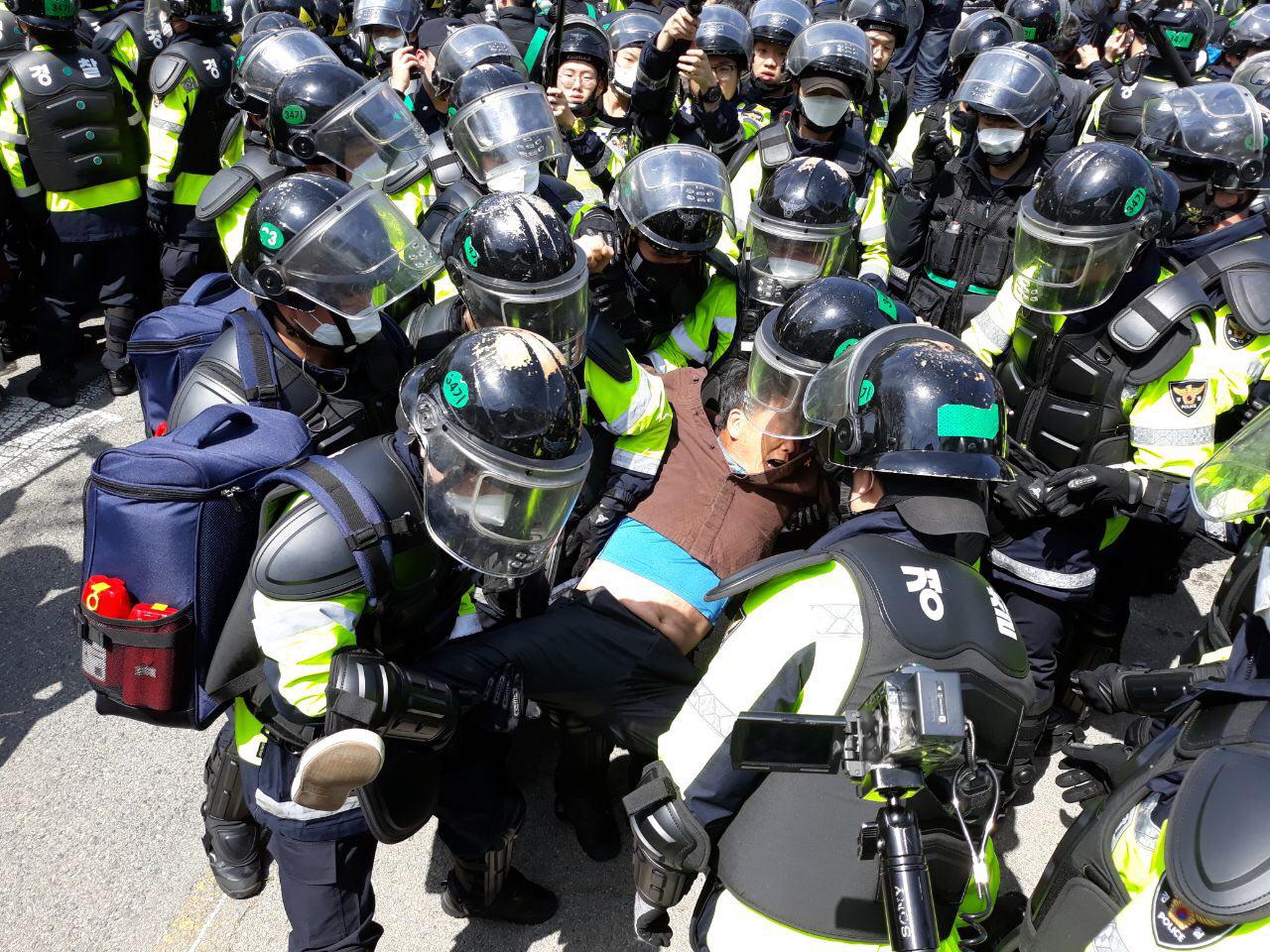 경찰이 12일 오전 사드(THAAD·고고도미사일방어체계) 기지에 공사 장비 등의 반입을 위해 주민들을 끌어내리고 있는 모습
