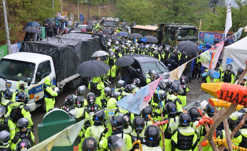 23일 오전 경북 성주군 초전면 소성리 진밭교 앞에서 경찰의 호의 속에 주한미군 사드(THAAD·고고도미사일방어체계) 기지의 생활공간 개선을 위한 건설장비와 자재 차량이 기지로 이동하고 있다.