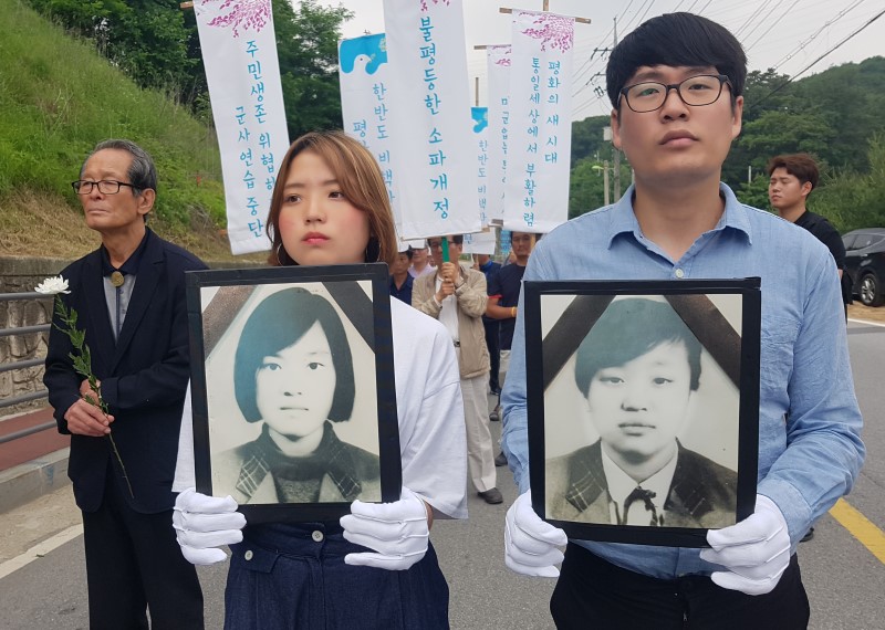 13일 오전 경기 양주시 광적면 효촌리 56번 국도 사고현장에서 추모객들이 영정을 들고 행진하고 있다.