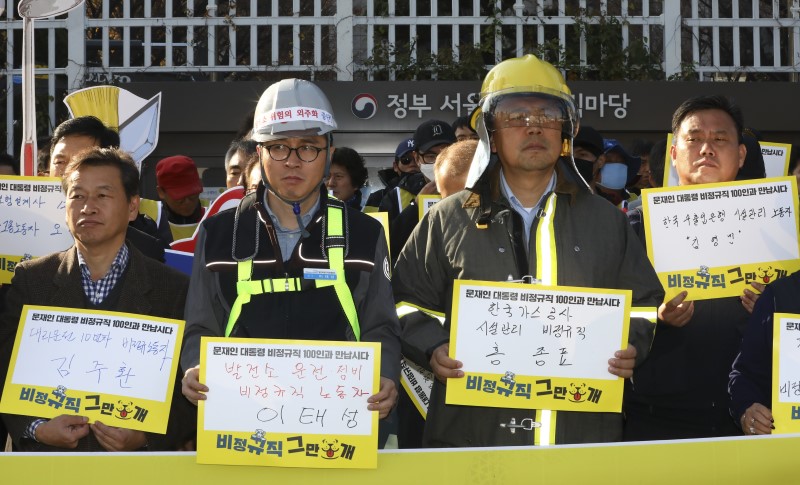 12일 서울 종로구 정부서울청사 앞에서 열린 민주노총 '1,100만 비정규직 노동자 공동투쟁 기자회견'에서 비정규직 노동자들이 문재인 대통령 면담 촉구 피켓을 들고 있다. 2018.11.12.