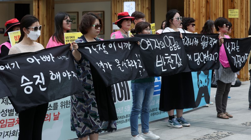 전국여성노조원, 한국여성노동자회원들이 17일 서울 종로구 광화문광장에서 열린 성별임금격차 해소를 위한 임금차별 타파의 날 기자회견에서 '가부장제, 남성생계부양자 이데올로기, 고용상 성차별' 등이 적힌 검은 천을 찢는 퍼포먼스를 하고 있다. 2019.05.17.