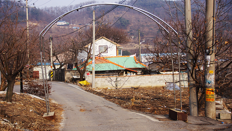 아산시 배방면 폐금광 학살 직전에 주민들을 감금했던 방앗간 터. 녹색 지붕의 주택이 그 장소다.