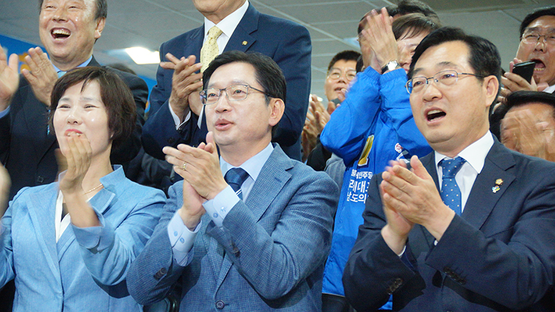 김경수 경남도지사 후보가 출구조사 결과가 발표가 나오자 환호하고 있다.