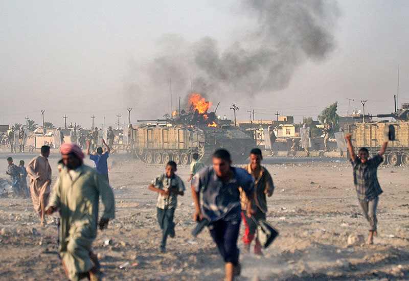 불타는 영국군 전차를 피해 달아나는 이라크인들. 영국군은 이라크 바스라 지역에서 고전했고, 결국 불명예스럽게 퇴각했다. 사진촬영은 2005.9.19.