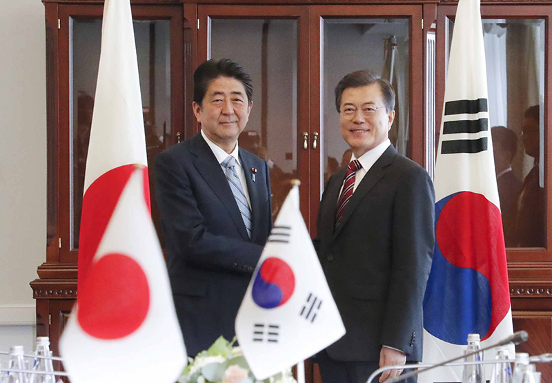 문재인 대통령이 7일 러시아 블라디보스토크 극동연방대에서 아베 신조 일본 총리와 한-일 정상회담 전 악수를 하고 있다.