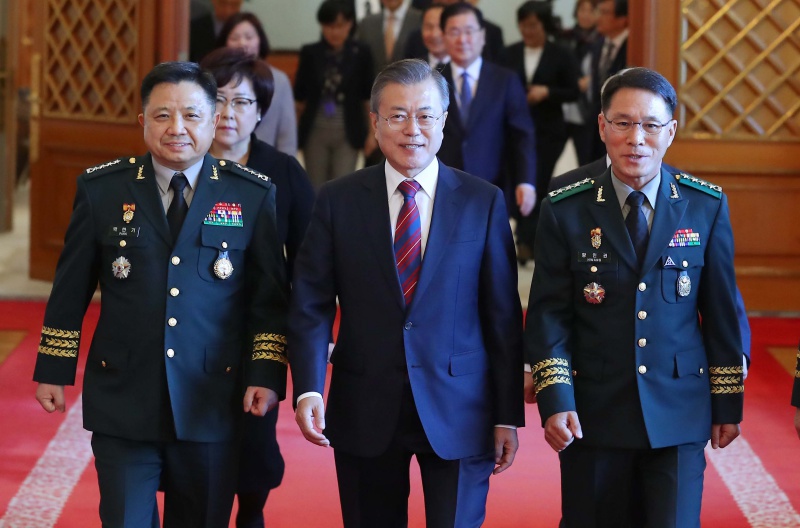 문재인 대통령이 12일 청와대 본관 충무실에서 열린 군 장성 진급 및 보직 신고를 마치고 환담장으로 이동하고 있다. 앞줄 왼쪽부터 박한기 합참의장, 문 대통령, 황인권 제2작전사령관.