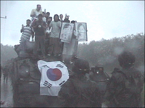 2002년 8월 대학생들이 여중생 압사사건에 항의하며 훈련중인 미군 장갑차 위에 올라 구호를 외치고 있다. 이 장면을 찍기 위해 김도균 기자는 꼬박 2박3일을 기다려야 했다.