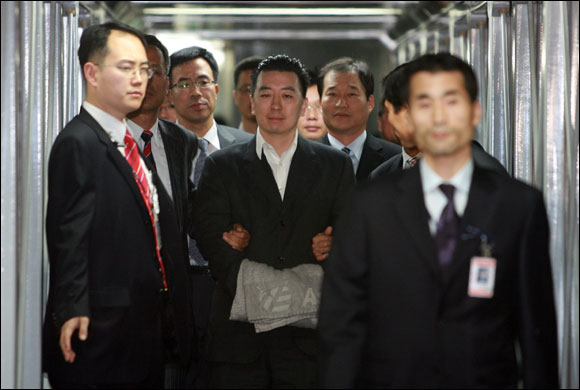 김경준씨잔 지난 2007년 11월 16일 저녁 법무부 호송팀에 의해 수갑이 채워진 채 인천공항에 도착하고 있다