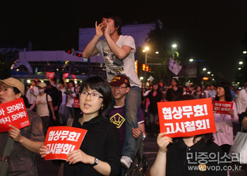 촛불문화제에 참가한 시민들이 "협상무효 고시철회" 등의 구호를 외치며 행진하고 있다.