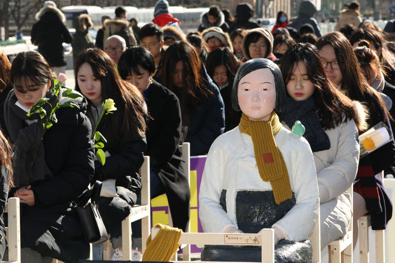 제 1315차 정기 수요집회 참가자들이 27일 오후 서울 종로구 광화문광장에서 위안부 문제 해결을 위한 2017 마지막 수요집회를 마친 뒤 '빈의자에 새긴 약속' 퍼포먼스를 하고 있다.