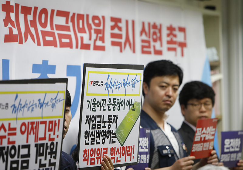 17일 오전 서울 중구 프레스센터에서 열린 '최저임금연대-양대노총 기자회견'에서 양대노총 조합원들이 최저임금 1만원 즉시 실현을 촉구하는 피켓을 들고 있다.