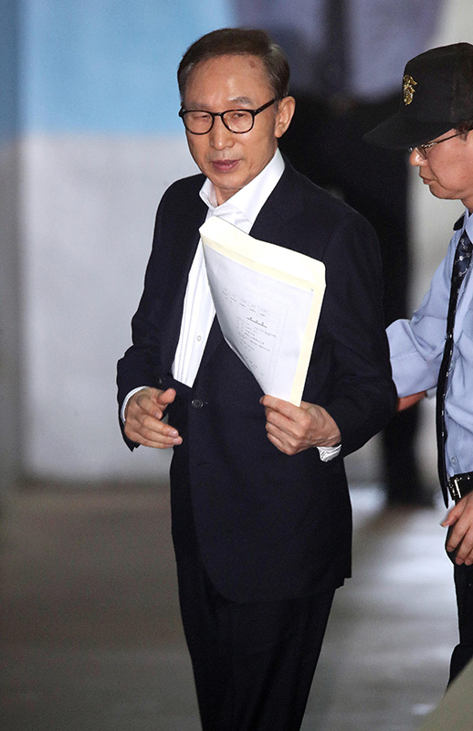 110억원대 뇌물수수와 350억원대 다스 횡령 등 혐의로 구속기소 된 이명박 전 대통령이 23일 오후 서울 서초구 서울중앙지방법원에서 열린 첫 공판에 출석하기 위해 호송차에서 내려 법정으로 향하고 있다.