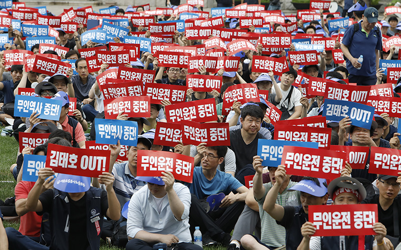 서울교통공사노동조합 조합원들이 11일 오전 서울 중구 서울광장에서 열린 '김태호 사장 퇴진촉구를 위한 조합원 총회'에서 무인운전 중단과 김태호 사장의 퇴진을 촉구하는 피켓을 들고 있다.