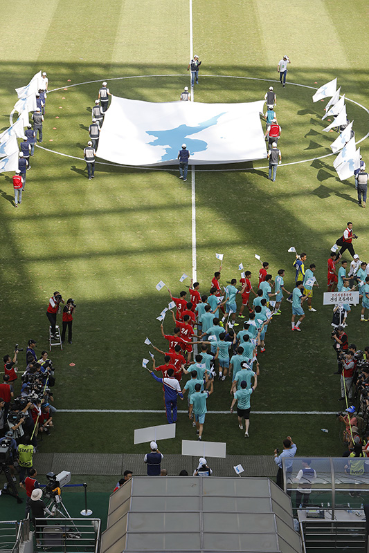 11일 오후 서울 마포구 상암월드컵경기장에서 열린 남북노동자 통일축구대회 개막식에서 한반도 단일기와 선수들이 입장하고 있다.