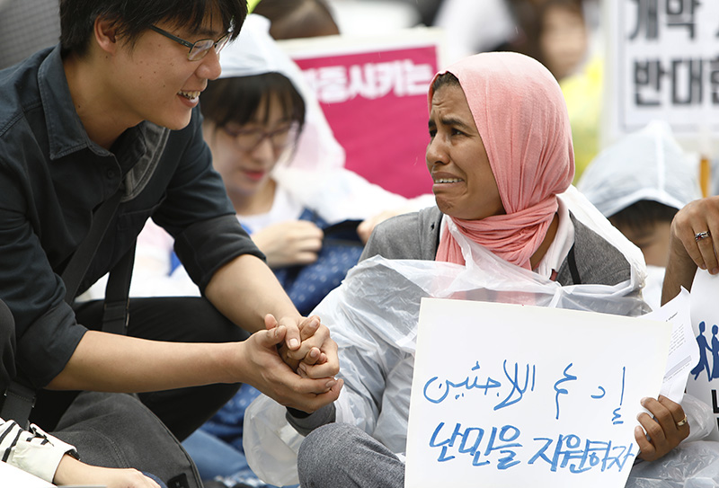 16일 오후 서울 보신각 앞에서 난민인권센터 주최로 열린 '난민과 함께하는 행동의 날' 집회에 참가한 한 난민이 집회 참가자에게 위로를 받고 있다.