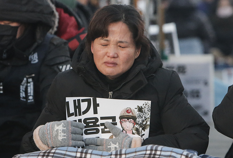 5일 오후 서울 광화문광장에서 열린 24살 청년 비정규직 고 김용균 3차 범국민 추모제에서 어머니 김미숙 씨가 피켓을 가슴에 품은 채 눈물을 흘리고 있다.