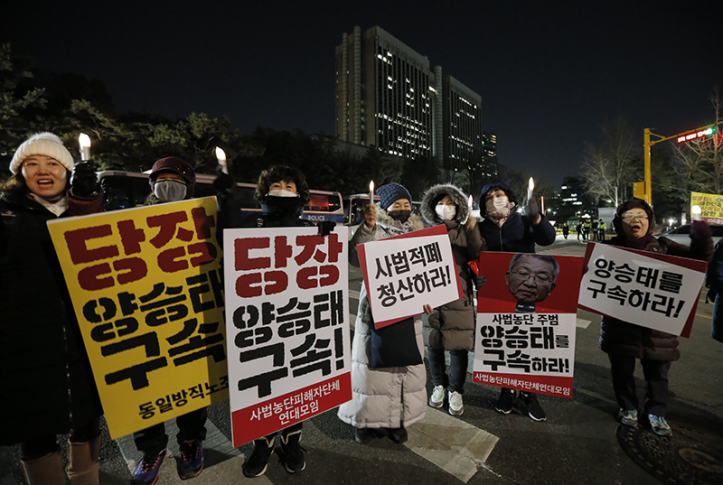 양승태 전 대법원장이 사법행정권 남용 의혹으로 영장실질심사를 마치고 서울구치소에서 대기중인 23일 밤 서울 서초구 서울중앙지방법원 정문 앞에서 시민사회단체 회원들이 촛불을 켜고 양승태 전 대법원장의 구속을 촉구하고 있다.