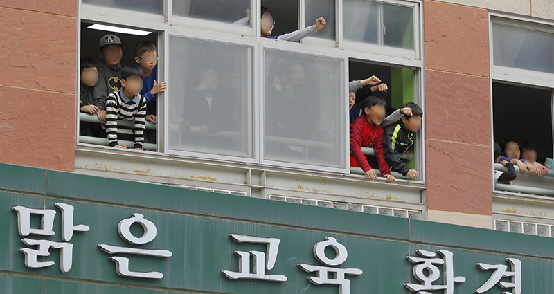 전두환 씨가 5·18 민주화운동 관련 피고인 신분으로 11일 광주지방법원에 들어서는 모습을 인근 초등학교 학생들이 바라보며‘‘전두환은 물러가라’’라고 외치고 있다.