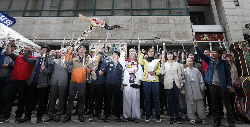 13년간 이어진 국내 최장기 노사분쟁 사업장인 콜텍 노사의 협상이 타결된 가운데 23일 서울 강서구 콜텍 본사 앞에서 열린 노사 교섭 합의 기자회견에서 이인근 금속노조 콜텍지회장을 비롯한 참석자들이 구호를 외치고 있다.