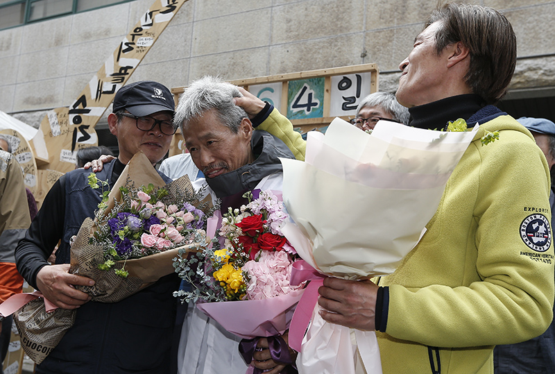 13년간 이어진 국내 최장기 노사분쟁 사업장인 콜텍 노사의 협상이 타결된 가운데 23일 서울 강서구 콜텍 본사 앞에서 열린 노사 교섭 합의 기자회견에서 이인근 금속노조 콜텍지회장과 임재춘 조합원, 김경봉 조합원이 서로 격려하고 있다.