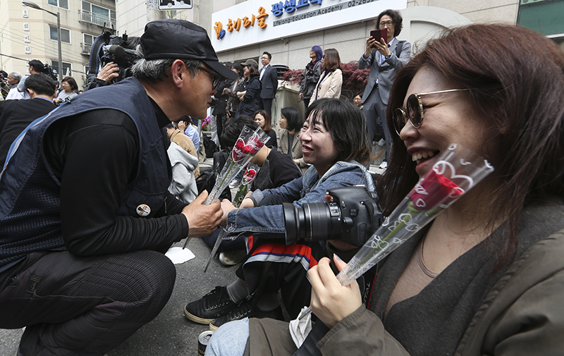 13년간 이어진 국내 최장기 노사분쟁 사업장인 콜텍 노사의 협상이 타결된 가운데 23일 서울 강서구 콜텍 본사 앞에서 열린 노사 교섭 합의 기자회견에서 김경봉 금속노조 콜텍지회 조합원이 기자회견 참석자들에게 꽃을 건네주고 있다.