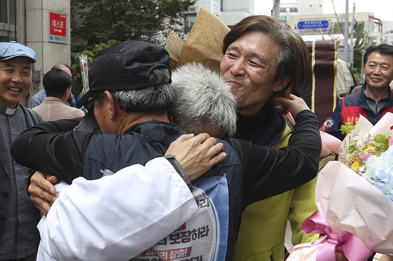 13년간 이어진 국내 최장기 노사분쟁 사업장인 콜텍 노사의 협상이 타결된 가운데 23일 서울 강서구 콜텍 본사 앞에서 열린 노사 교섭 합의 기자회견에서 이인근 금속노조 콜텍지회장과 김경봉 조합원, 전날까지 42일간 단식한 임재춘 조합원이 서로를 끌어안고 있다.