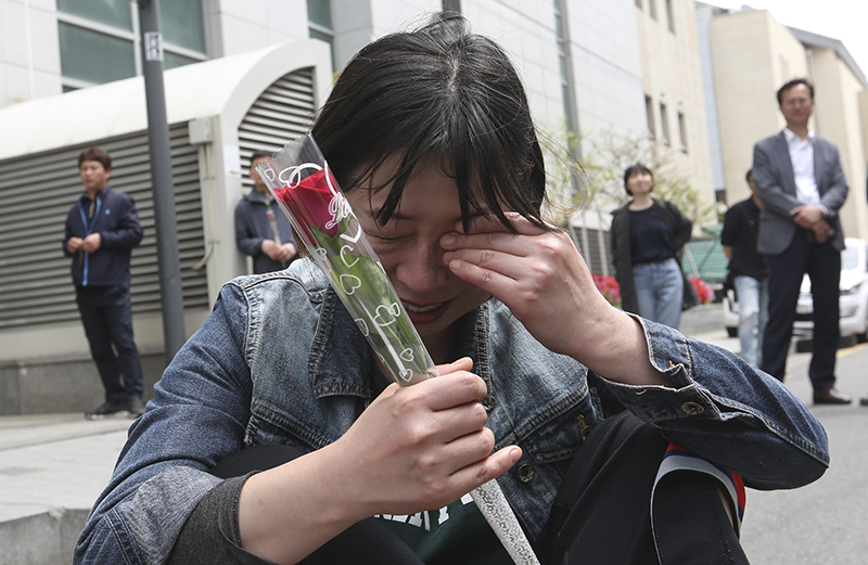 13년간 이어진 국내 최장기 노사분쟁 사업장인 콜텍 노사의 협상이 타결된 가운데 23일 서울 강서구 콜텍 본사 앞에서 노사 교섭 합의 기자회견에서 김경봉 금속노조 콜텍지회 조합원에게 꽃을 건네받은 참가자가 눈물을 흘리고 있다.