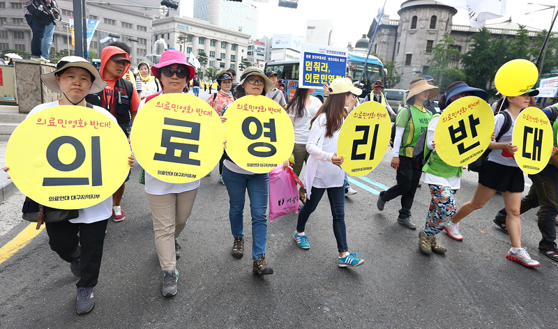 의료연대 조합원들이 의료영리화 반대 피켓을 들고 청계광장을 향해 행진하고 있다.