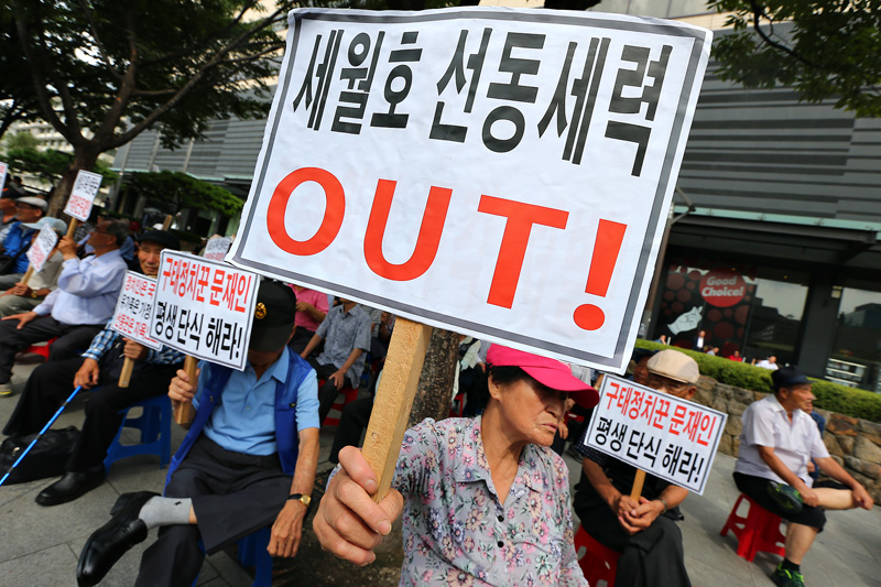 보수단체 회원들이 2014년 8월 27일 서울 광화문 광장 건너편에서 집회를 열고 세월호 특별법 제정을 촉구하며 단식농성 중인 유가족 김영오 씨와 문재인 새정치민주연합 상임고문을 규탄하고 있다.