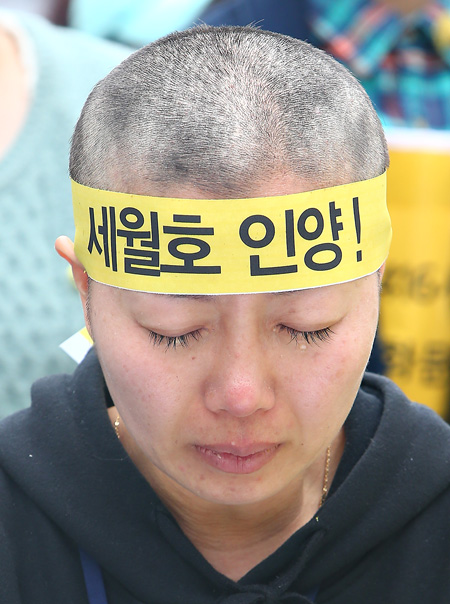 세월호 참사 유가족이 2일 오후 서울 광화문광장의 농성장에서 삭발을 마친 뒤 눈물을 흘리고 있다. 세월호 가족협의회는 삭발식을 하며 정부에게 배보상 절차 전면 중단과 조속한 세월호 선체 인양, 시행령안 즉각 폐기를 촉구했다.