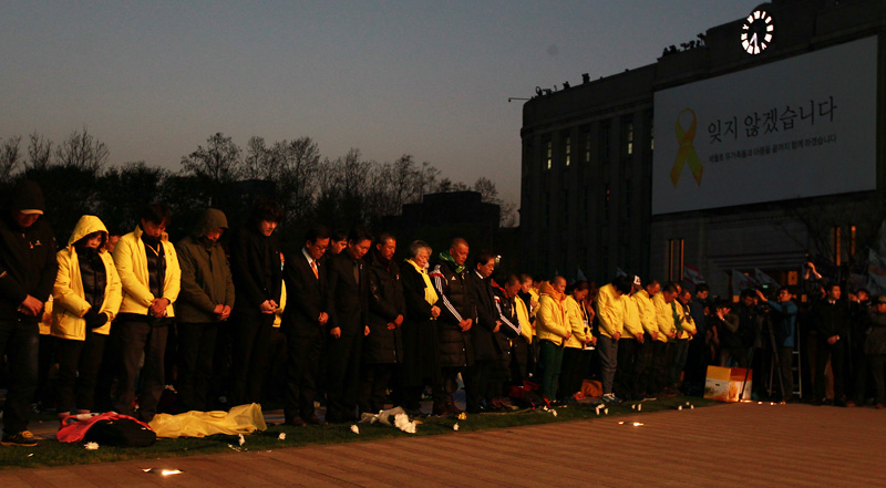 세월호 참사 희생자 및 피해자 가족과 시민들이 참사 1주기인 16일 오후 서울 시청광장에서 열린 범국민추모제 '4.16 약속의 밤'에서 희생자들을 위해 묵념하고 있다.