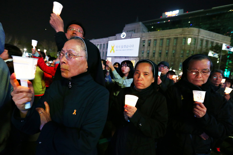 세월호 참사 1주기를 맞아 시민 4160명이 17일 저녁 서울 시청광장에서 촛불을 들고 세월호 형상을 만들며 희생자들을 추모하고 있다. 참가자들은 영국 세계기네스협회의 '사람이 만든 가장 큰 촛불 이미지' 부문의 기록을 갱신했다.