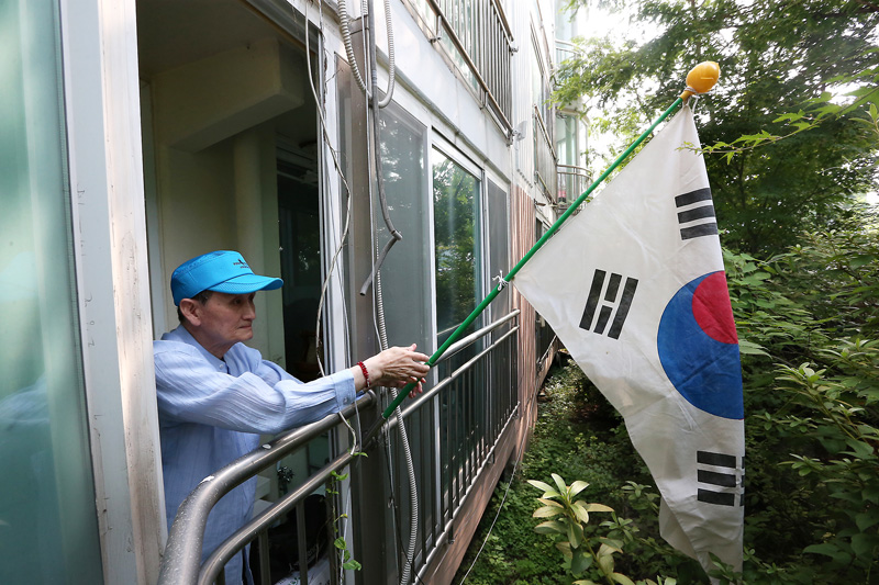 김정륙 씨가 15일 오전 경기도 의정부 자택에서 태극기를 계양하고 있다.