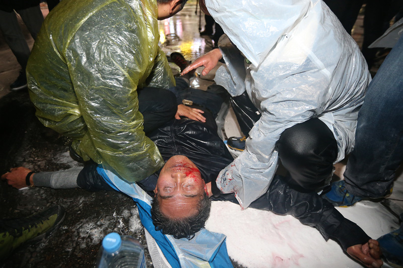 14일 오후 서울 종로구청입구 사거리에서 민중총궐기 참가자들이 경찰과 대치 중인 가운데 경찰 물대포를 맞고 실신한 농민이 피를 흘리며 쓰러져 있다.