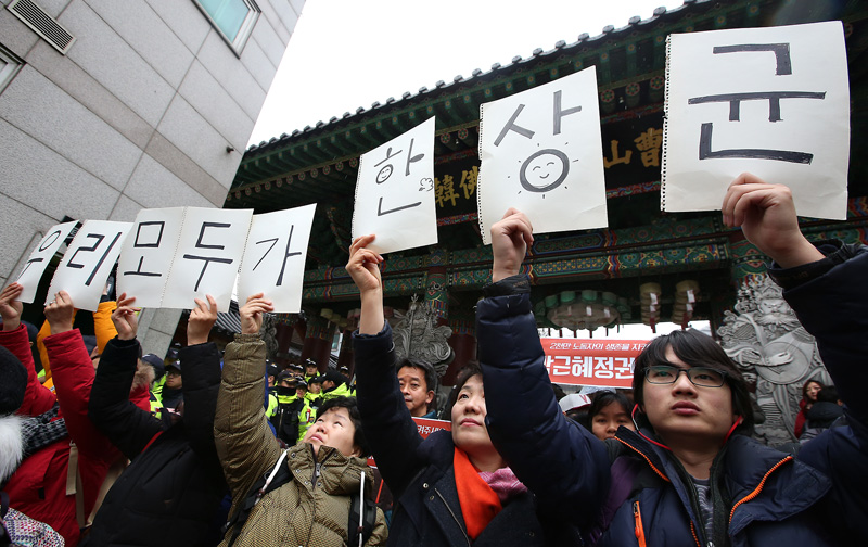 2015년 12월 10일 오전 서울 조계사 일주문 앞에서 시민들이 피켓을 들고 경찰에 자친출두한 한상균 민주노총 위원장을 격려하고 있다.