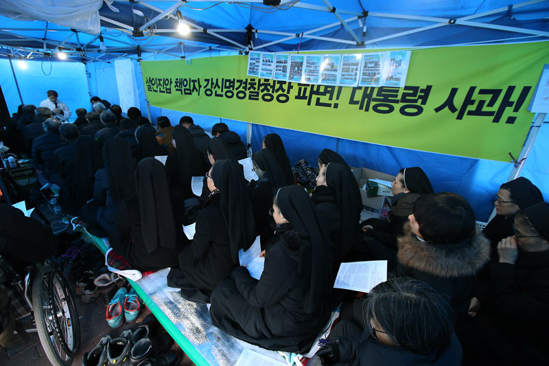 25일 오후 서울 종로구 서울대병원 앞 백남기 농민 쾌유 기원 농성장에서 열린 성탄대축일 미사에서 참석자들이 백남기 농민의 쾌유와 경찰의 물대포 살수에 대한 진상규명 및 책임자 처벌을 요구하고 있다.